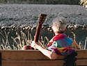 Colleen Crosson sitting on a bench near the river